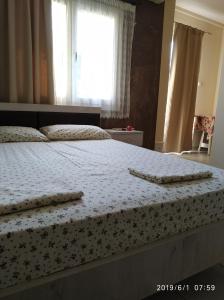 a bedroom with a bed with two towels on it at LAZAROS APARTMENTS in Olympic Beach