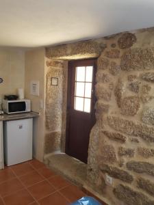 a kitchen with a door in a stone wall at Casa Dr. Saba in Belmonte