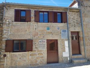 un antiguo edificio de piedra con puertas y ventanas de madera en Casa Dr. Saba, en Belmonte