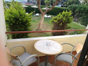 a table and chairs on a balcony with an umbrella at Golden days in Afantou