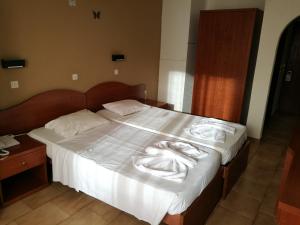 a bed with white sheets and towels on it at Golden days in Afantou