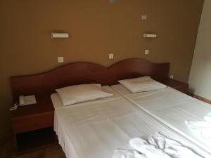 a bed with two white pillows on top of it at Golden days in Afantou