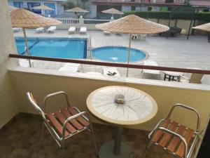 a balcony with a table and chairs and a pool at Golden days in Afantou