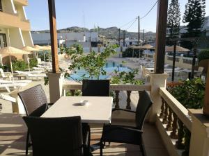 a table and chairs on a balcony with a pool at Golden days in Afantou