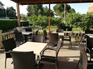 an outdoor patio with tables and chairs and trees at Golden days in Afantou