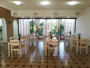 a dining room with tables and chairs and windows at Golden days in Afantou