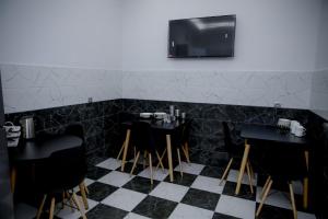 a restaurant with black chairs and a tv on the wall at EUPHORIA Mariam in Tbilisi City