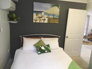 a bed with two pillows and a picture on the wall at Casuarina in Yeppoon