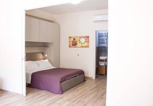 ein Schlafzimmer mit einem Bett mit einer lila Decke in der Unterkunft Casa Lorenzo in Taormina