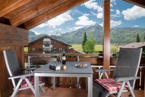a table and chairs on a balcony with a view at Landhaus Dodel in Oberstdorf