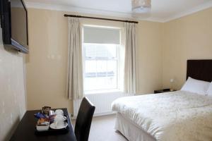 a hotel room with a bed and a desk with a table sidx sidx at Desota House Bed and Breakfast in Galway