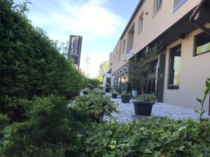 ノヴァ・ゴリツァにあるDAM boutique hotel & restaurantの植物の植えられた建物の前の庭
