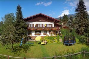 a house with people sitting in the yard at Pension Montana in Wagrain