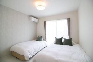 2 Betten in einem Zimmer mit Fenster in der Unterkunft beautiful Mt.Fuji B in Fujikawaguchiko