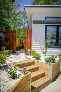 a garden with wooden steps in front of a house at Myrtle Tree Lodge - Trunks in Kangaroo Valley