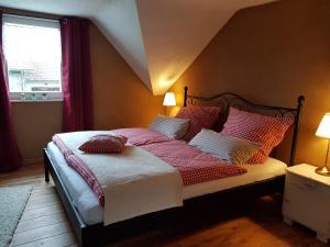 ein Schlafzimmer mit einem Bett mit roten und weißen Kissen in der Unterkunft super gemütlich - DasPaterhaus in Monschau