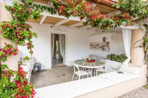 an outdoor patio with a table and flowers at Villa Sea Rose in Lipari