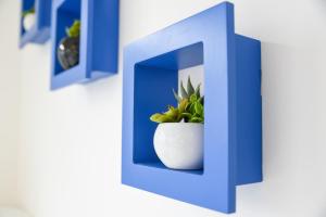a blue letter h with a plant in a vase at Bed and Breakfast Porto Flavia in Iglesias