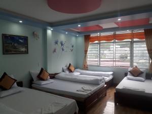 a room with three beds and a window at Binh Minh Hostel in Dồng Văn