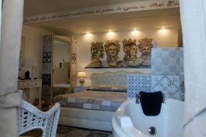 a room with a bed, a chair, and a mirror at B&B Triskèles in Giardini Naxos