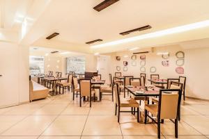 a dining room filled with tables and chairs at Hotel Summit in Ahmedabad