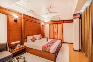 a bedroom with a bed and a chair and a couch at Hotel Summit in Ahmedabad