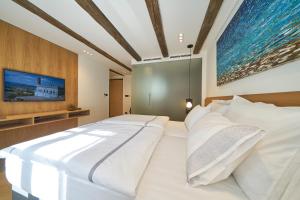 a large white bed in a room with a tv at Villa Pergola in Šibenik