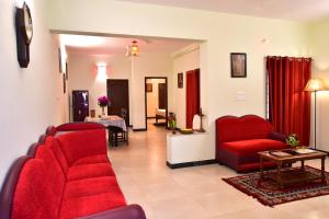 a living room with red chairs and a table at Villa Gomez in Puducherry