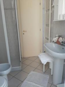 a white bathroom with a sink and a shower at Residence Marina in Alassio