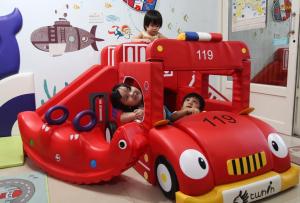 恆春的住宿－海角42號民宿- 二館 (親子主題館)，两个孩子在玩具消防车里玩耍