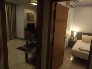 Postel nebo postele na pokoji v ubytování Goa Woodlands Hotel