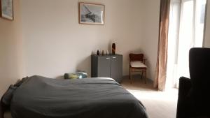 ein Schlafzimmer mit einem Bett, einem Tisch und einem Stuhl in der Unterkunft Tiguil in Le Guilvinec