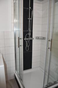 una doccia con porta in vetro in bagno di Vicky´s Ferienwohnung a Flensburgo