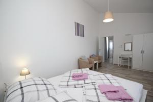 a bedroom with a bed with pink towels on it at Apartments Lavanda - Kricin in Baška