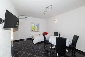 a room with two beds and a table and chairs at Villa Gorica Apartments Ražanj in Ražanj