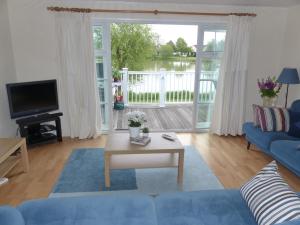 a living room with a blue couch and a table at Nyhavn Lakeside Cottage in Cirencester +43 photos