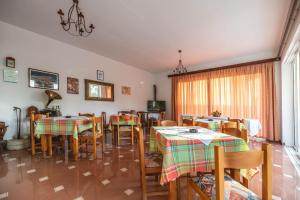 een eetkamer met tafels en stoelen en een raam bij Hotel Ikaros in Archangelos