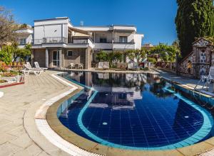 a swimming pool in front of a house at Hotel Ikaros in Archangelos