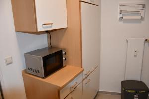 Un four micro-ondes est installé au-dessus d'une armoire en bois. dans l'établissement Vicky´s Ferienwohnung, à Flensbourg 2 autres photos