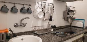 kuchnia ze zlewem i przyborami kuchennymi na ścianie w obiekcie Apartment Edificio Sur 19 w mieście Nerja +18 zdjęć