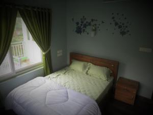 1 cama pequeña en un dormitorio con ventana en Honeybee residency Vagamon, en Vagamon