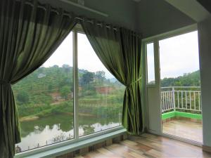 a room with large windows with a view of a river at Honeybee residency Vagamon in Vagamon