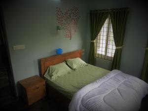 a bedroom with a bed and a window at Honeybee residency Vagamon in Vagamon +9 photos