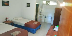 a hotel room with two beds and a bathroom at Mahu Lodge in Noloth +17 photos