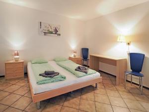 a bedroom with a bed and two blue chairs at Apart Holidays - Residenza Flora in Locarno +52 photos