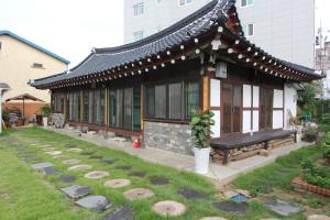 a building with a bench in a yard at Dasomchae Hanok stay in Gwangju