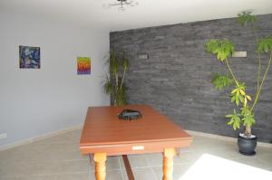 a room with a wooden table and two plants at Maison individuelle in Brette-les-Pins