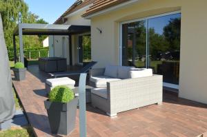 a patio with a couch and chairs on a patio at Maison individuelle in Brette-les-Pins