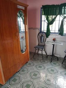 a room with a chair and a table and a mirror at Nhà Trọ Kim Ánh in Long Xuyên