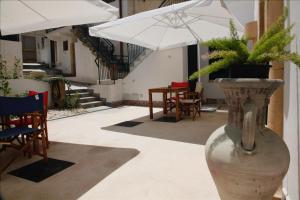 a vase with a plant in it with chairs and an umbrella at Storie di mare in Marsala